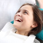 young girl smiling in dental chair
